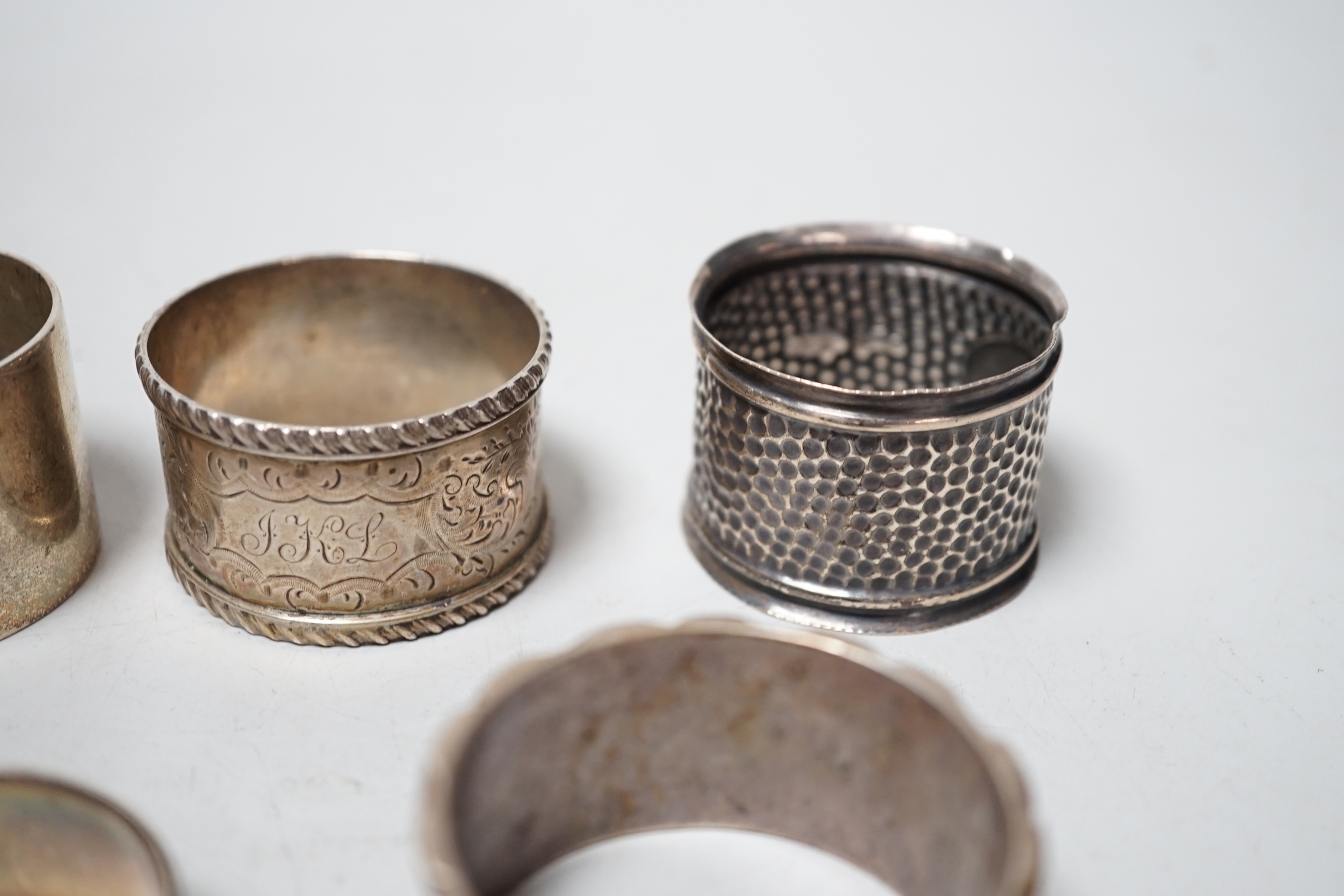 Five assorted silver napkin rings.